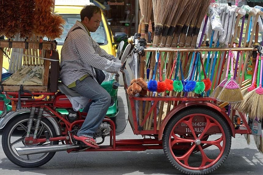 A Thai broom vendor riding a tricycle on the streets of Bangkok on Sept 1, 2014.&nbsp;In Thailand, Car Free Day is taking place in all 77 provinces, and in Bangkok, traffic police are sealing off parts or all of some major roads today and tomorrow. T