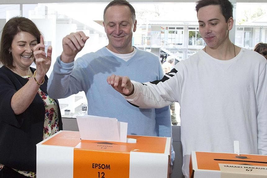 New Zealand's National Party leader John Key (middle) casts his vote with his wife Bronagh (left) and his son Max on election day during New Zealand's general election in Auckland on Sept 20, 2014. -- PHOTO: REUTERS