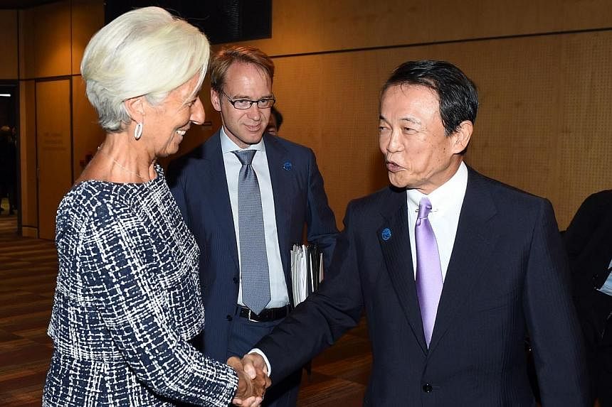 Head of the IMF Christine Lagarde greets Japan's Finance Minister Taro Aso at the G20 Finance Ministers and Central Bank Governors Meeting in Cairns on Sept 20, 2014. -- PHOTO: AFP