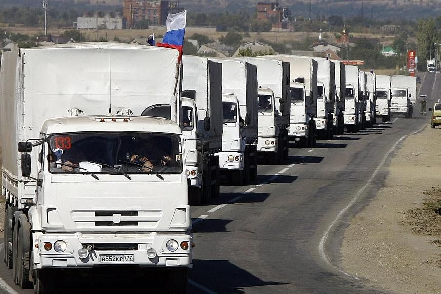 Lorries, part of a Russian humanitarian convoy, approach to the Ukrainian border at the Donetsk-Izvarino border checkpoint on Sept 19, 2014. -- PHOTO: AFP
