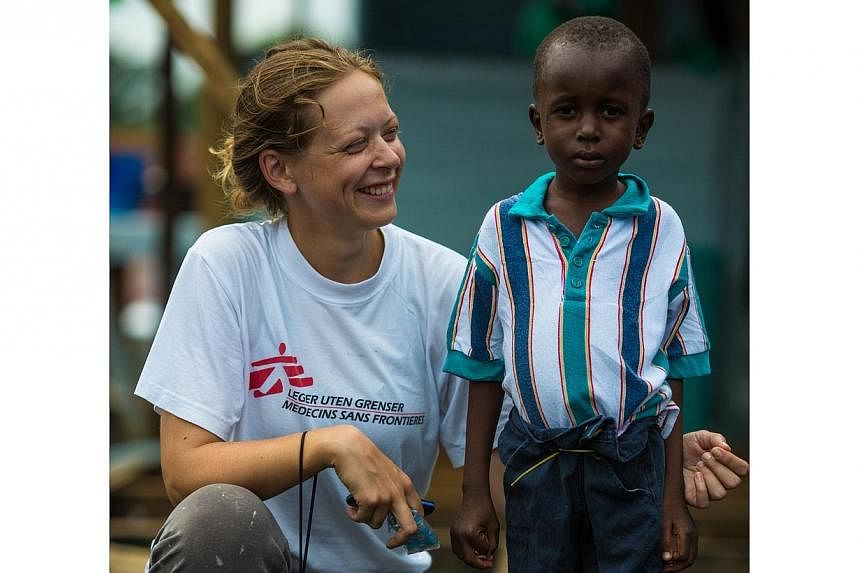 Ane Bjøru Fjeldsæter, an MSF mental health manager from Norway, with Ebola survivor Patrick, six, at ELWA 3 - the Ebola Case Management Center run by MSF.&nbsp;Liberia is divided by an orange double fence. -- PHOTO: MORGANA WINGARD