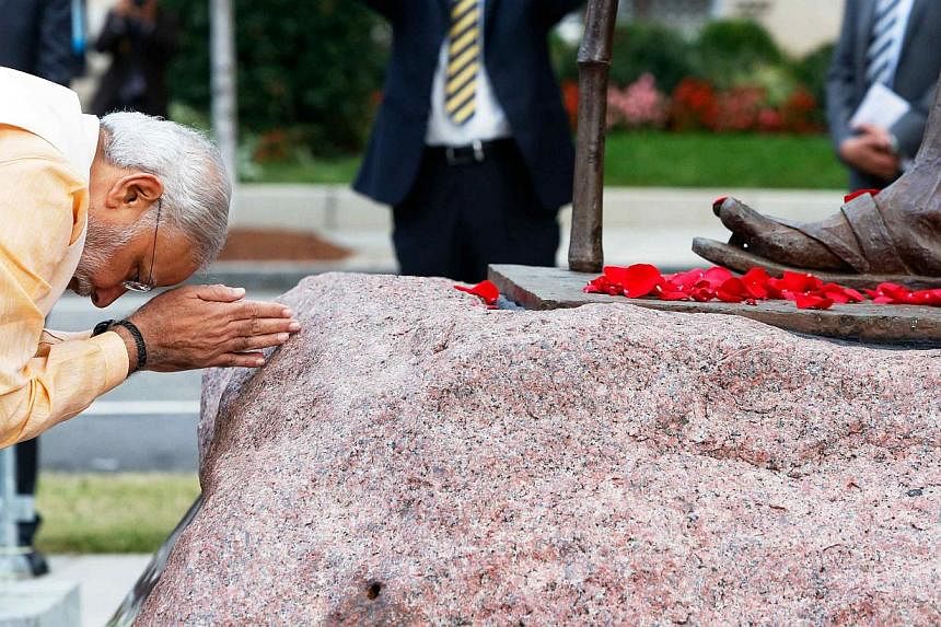 India's Prime Minister Narendra Modi bows his head after scattering flower petals at the feet of the Mahatma Gandhi Statue outside the Indian Embassy in Washington on Sept 30, 2014. -- PHOTO: REUTERS