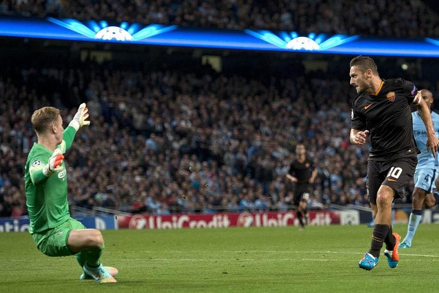 Roma's Italian forward Francesco Totti (right) scores the equalising goal past Manchester City's English goalkeeper Joe Hart (left) during the Champions League Group E football match between Manchester City and Roma in Manchester, Northwest England, 