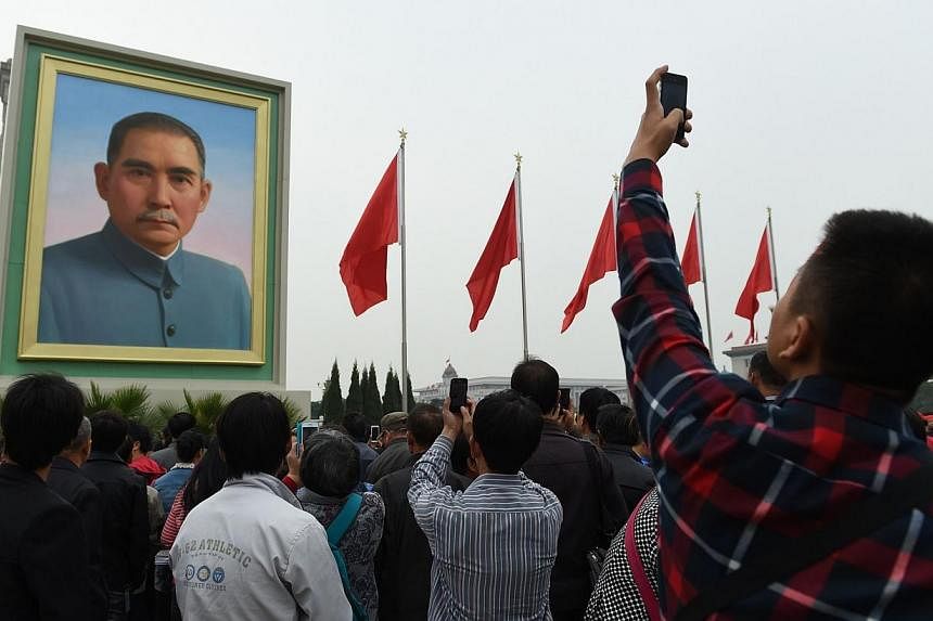 A man takes photos of a portrait of Sun Yat-sen in Beijing's Tiananmen Square on China's National Day, Oct 1, 2014.&nbsp;Fearful of comparisons to the 1989 Tiananmen Square crackdown, Beijing has launched a dual effort to suppress news of swelling pr
