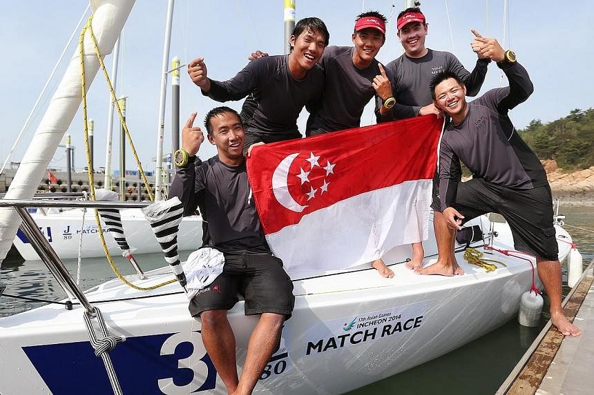 (From left) Singapore's Justin Wong, skipper Maximilian Soh, Russell Kan, Christopher Lim and Andrew Paul Chan after bagging Singapore's third sailing gold medal at the Incheon Asian Games on Oct 1, 2014. -- ST PHOTO: NEO XIAOBIN