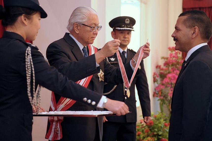 Singapore President Tony Tan Keng Yam&nbsp;presents a distinguished service order medal to Interpol secretary-general Ronald Noble at the Istana on Oct 1, 2014. Mr Noble played an important role in fostering close ties between Singapore and Interpol,