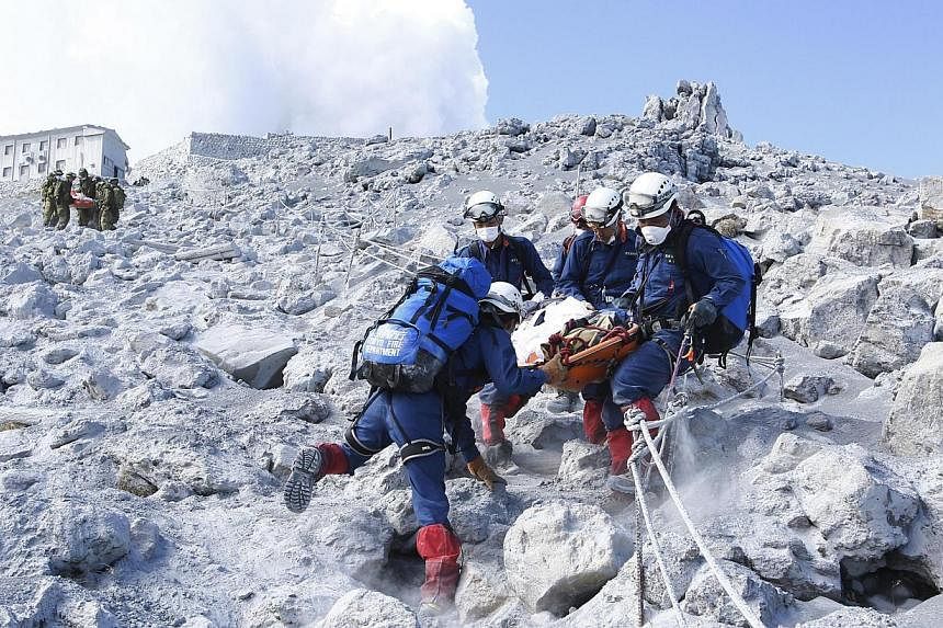 Firefighters carry a hiker during rescue operations near the peak of Mount Ontake in central Japan in this handout photograph released by the Tokyo Fire Department and taken on Sept 28, 2014. -- PHOTO: REUTERS&nbsp;