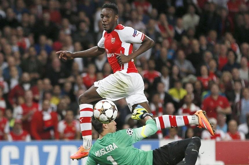 Arsenal's Danny Welbeck (top) scores a goal past Galatasaray's goalkeeper Fernando Muslera during their Champions League match at the Emirates Stadium in London on Oct 1, 2014. -- PHOTO: REUTERS &nbsp;