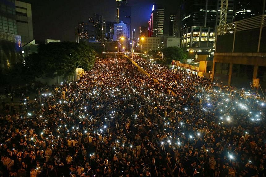 A sea of lights as protesters hold up their mobile phones while blocking the main road to the financial district in Hong Kong on Sept 29, 2014. -- PHOTO: REUTERS