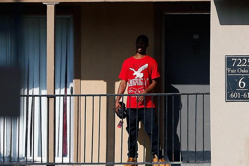 A man stands outside a unit at the Ivy Apartments, where the confirmed Ebola virus patient was staying, on Oct 1, 2014 in Dallas, Texas. -- PHOTO: AFP