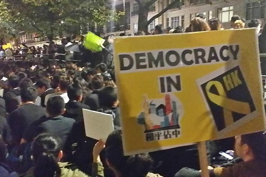 Dressed in black and toting umbrellas and yellow placards, more than 1,000 people turned up on Wednesday night in London's West End in a show of support for Hong Kong's ongoing pro-democracy campaign. -- ST PHOTO: TAN DAWN WEI