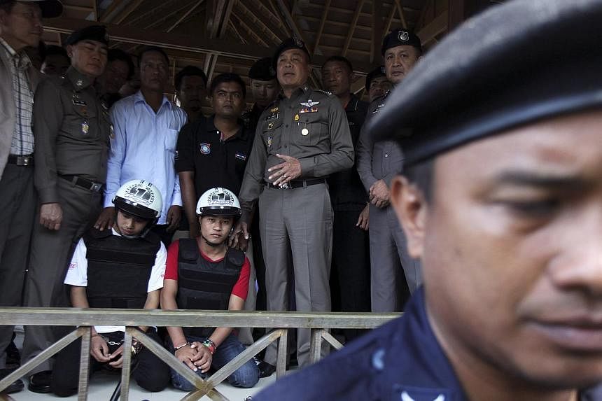 Thai national police chief Police General Somyot Poompanmoung (centre) stands next to two detained workers from Myanmar, suspected of killing two British tourists on the island of Koh Tao last month, on Oct 3, 2014.&nbsp;Two Myanmar workers have conf