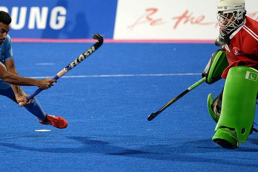 Indian player Dharamvir Singh (left) scores the final goal in the penalty shoot-out of the men's hockey final against Pakistan. It was a chance for both countries - who were once giants in the game - to recapture past glory and spark off a revival of