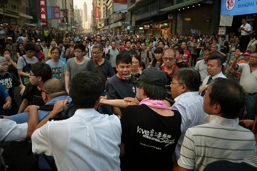 A protester reacts as he gets kicked after entering the area where the anti-protesters as gathered in Mong Kok in Kowloon on Oct 3, 2014. -- ST PHOTO:&nbsp;KUA CHEE SIONG
