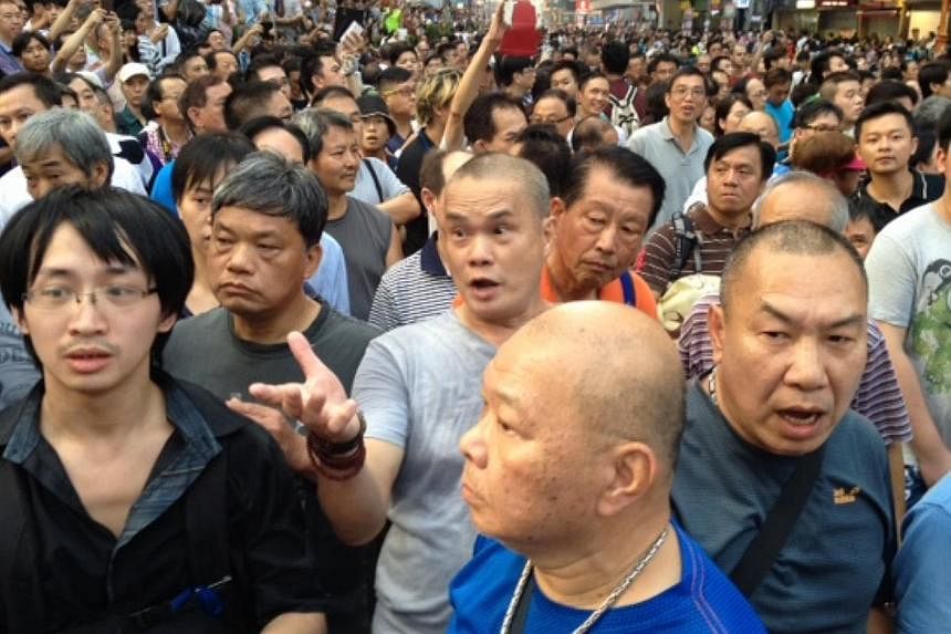 Scuffles between pro-democracy protesters and groups supporting Beijing broke out in a key Hong Kong shopping district on Friday, prompting police to form a human chain between them. --&nbsp;ST PHOTO: KUA CHEE SIONG