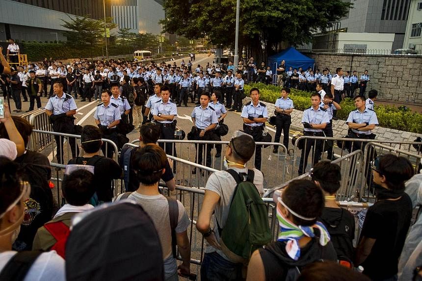 Police line up next to government offices in Hong Kong on Oct 3, 2014. -- PHOTO: AFP