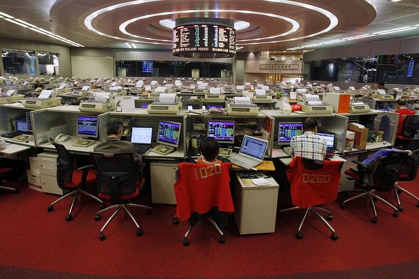 Floor traders work during afternoon trading at the Hong Kong Stock Exchange in this Nov 6, 2013 file photo.-- PHOTO: REUTERS