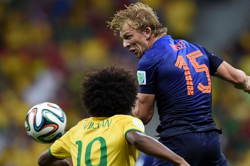 Netherlands' midfielder Dirk Kuyt (right) challenges Brazil's midfielder Willian during the third place play-off football match between Brazil and Netherlands during the 2014 FIFA World Cup at the National Stadium in Brasilia on July 12, 2014. Kuyt a