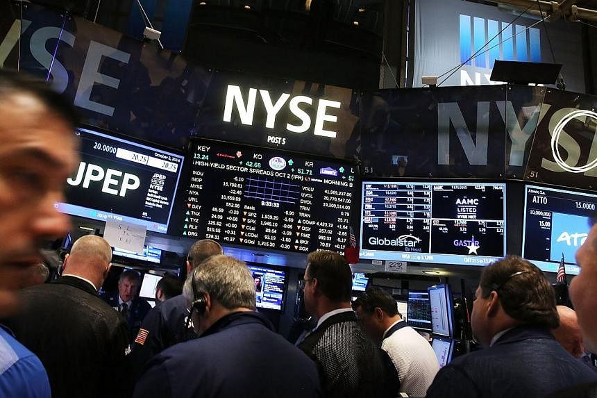 Traders work on the floor of the New York Stock Exchage in New York City on Oct 2, 2014. -- PHOTO: AFP