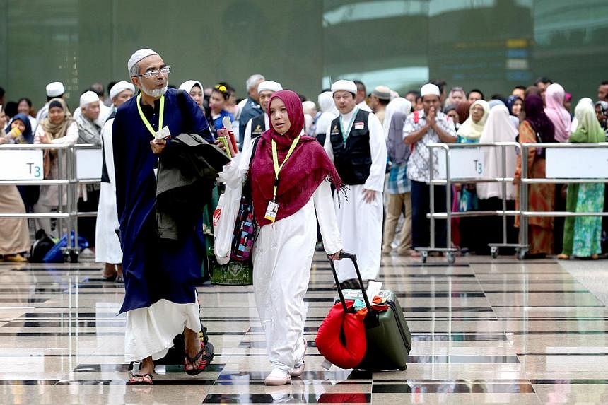 Family members and friends gathered at Changi Airport’s Terminal 3 on Oct 3, 2013, for an emotional farewell to their loved ones going for their haj. -- ST PHOTO: CHEW SENG KIM