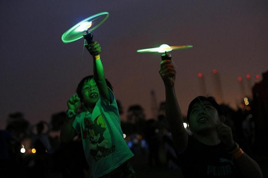 Cheow Jun Wei plays with a LED flying disc alongside his father, Cheow Yoon Foo. -- PHOTO: DESMOND LUI FOR THE STRAITS TIMES&nbsp;