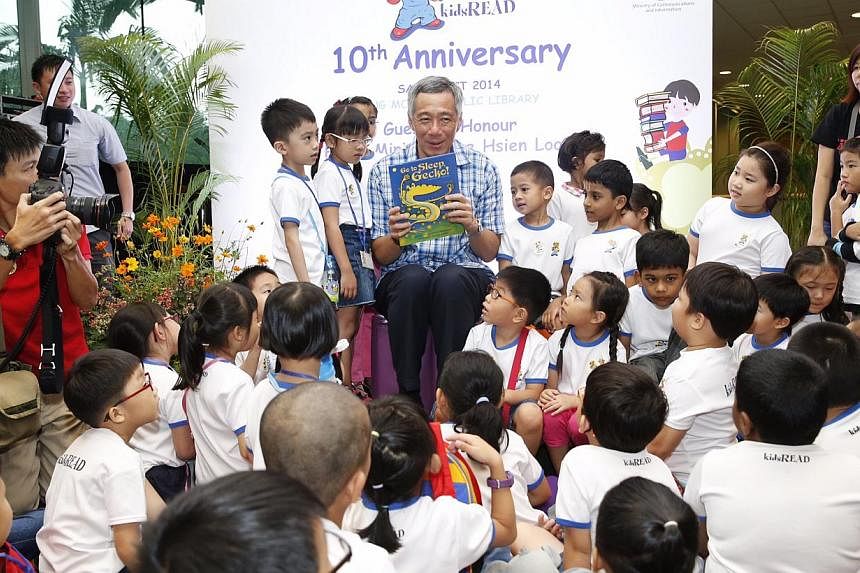 Prime Minister Lee Hsien Loong reads a story book titled 'Go to sleep, Gecko!' to kids during National Library Board's 10th year celebration of kidsREAD at Ang Mo Kio Public Library on Oct 4, 2014. -- ST PHOTO: KEVIN LIM