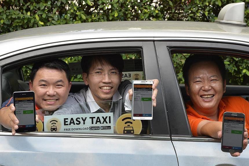 Cabbies (from left) Lee Chee Beng, Alvin Tan and Armstrong Ho showing the Easy Taxi app on their phones. Easy Taxi's decision not to charge a fee for credit card payments could prove a hit with customers.