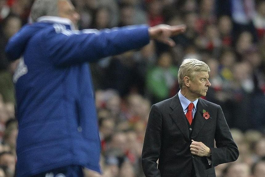 Arsenal's manager Arsene Wenger (right) watches as Chelsea's manager Jose Mourinho points during their English League Cup fourth round soccer match at Emirates Stadium in London on Oct 29, 2013. -- PHOTO: REUTERS