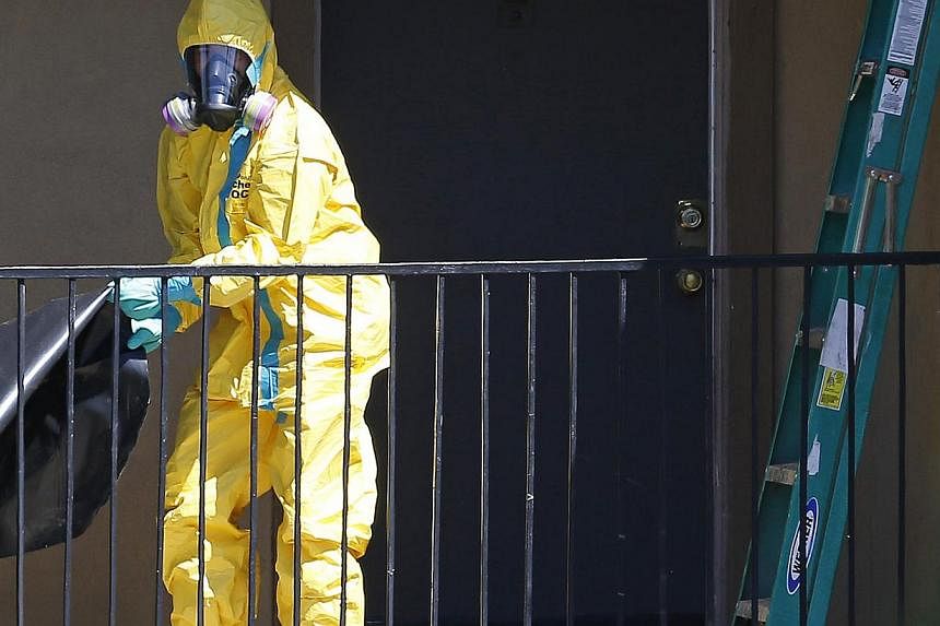 A worker wearing a hazardous material suit arrives at the apartment unit where a man diagnosed with the Ebola virus was staying in Dallas, Texas, Oct 3, 2014. Four people close to Liberian citizen Thomas Eric Duncan, the first person diagnosed with E