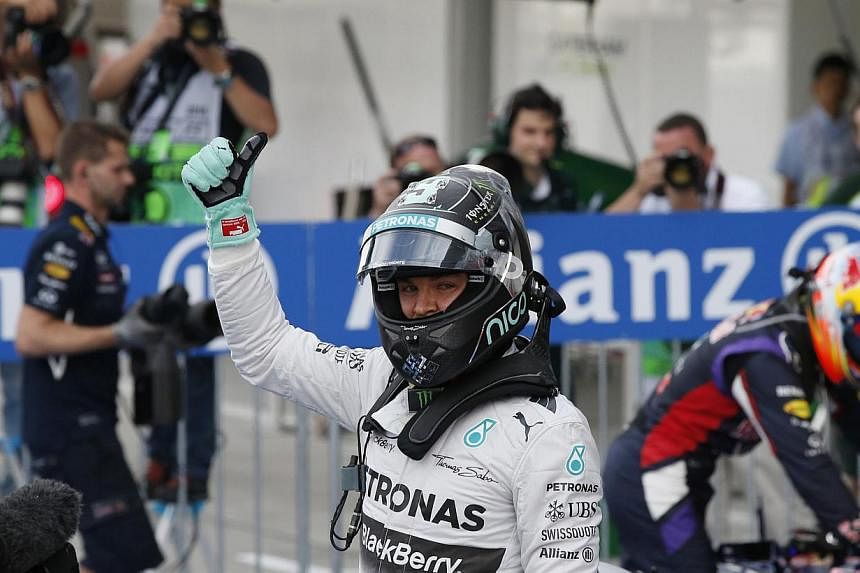 Mercedes Formula One driver Nico Rosberg of Germany gives a thumbs up as he celebrates winning pole position in the qualifying session of the Japanese F1 Grand Prix at the Suzuka Circuit on Oct 4, 2014. -- PHOTO: REUTERS
