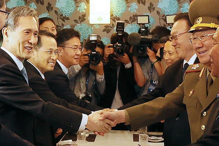 South Korea's national security advisor Kim Kwan Jin (left) shakes hands with North Korea's&nbsp;General Political Bureau director&nbsp;Hwang Pyong So (second from right) during a luncheon meeting in Incheon, west of Seoul, on Oct 4, 2014. -- PHOTO: 