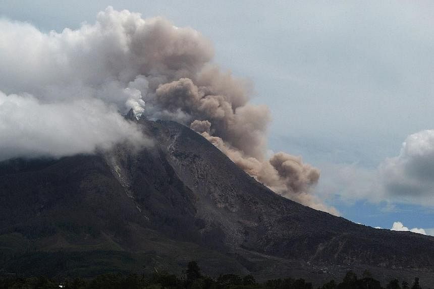 Indonesia's Mt Sinabung spewing ash on Aug 14, 2014, on Sumatra Island. The volcano erupted again on Sunday, Oct 5, sending columns of ash up to 3,000m into the sky. -- PHOTO: AFP
