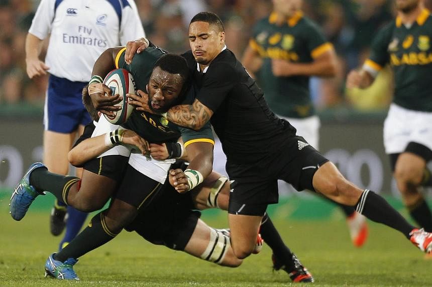 New Zealand's Aaron Smith (right) tackles South Africa's Tendai Mtawarira during their Rugby Championship match at Ellis Park stadium in Johannesburg Oct 4, 2014. -- PHOTO: REUTERS