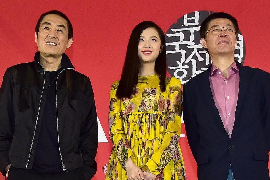 (From left)&nbsp;Chinese director Zhang Yimou, actress Zhang Huiwen and producer Zhang Zhao at a press conference on the gala presentation of the film Coming Home at the 19th Busan International Film Festival in Busan on Oct 4, 2014. -- PHOTO: AFP