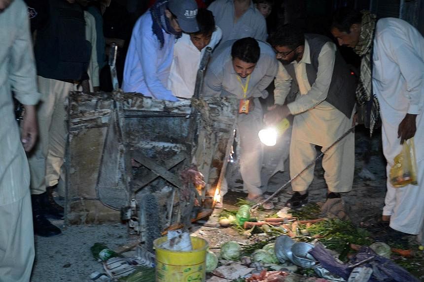 Pakistani security officials and Shi'ite Muslims inspect the site of suicide bomb attack in Quetta on Oct 4, 2014. At least five people were killed and 25 others wounded when a suicide bomber blew himself up on Oct 4, 2014 in a minority Shi'ite colon