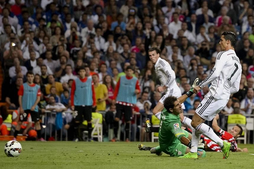 Real Madrid's Portuguese forward Cristiano Ronaldo shoots to score during the Spanish league football match against Athletic Bilbao at the Santiago Bernabeu stadium in Madrid on Oct 5, 2014. -- PHOTO: AFP
