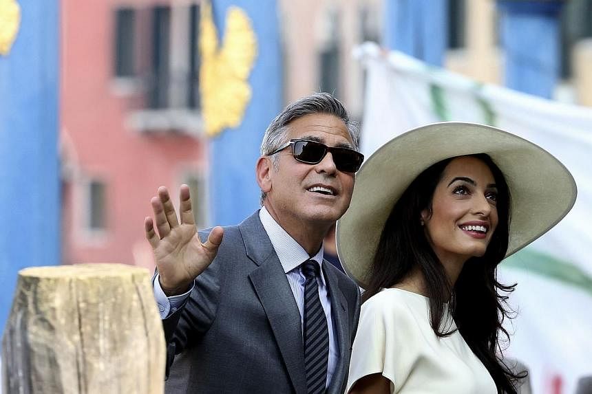 US actor George Clooney and his wife Amal Alamuddin arrive at Venice city hall for a civil ceremony to formalize their wedding in Venice Sept 29, 2014. -- PHOTO: REUTERS&nbsp;