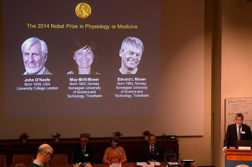 A giant screen displays the image of British-American researcher John O'Keefe and Norwegian duo May-Britt Moser and Edvard I Moser at a press conference of the Nobel Committee to announce the winner of the 2014 Nobel Medicine Prize on Oct 6, 2014 at 