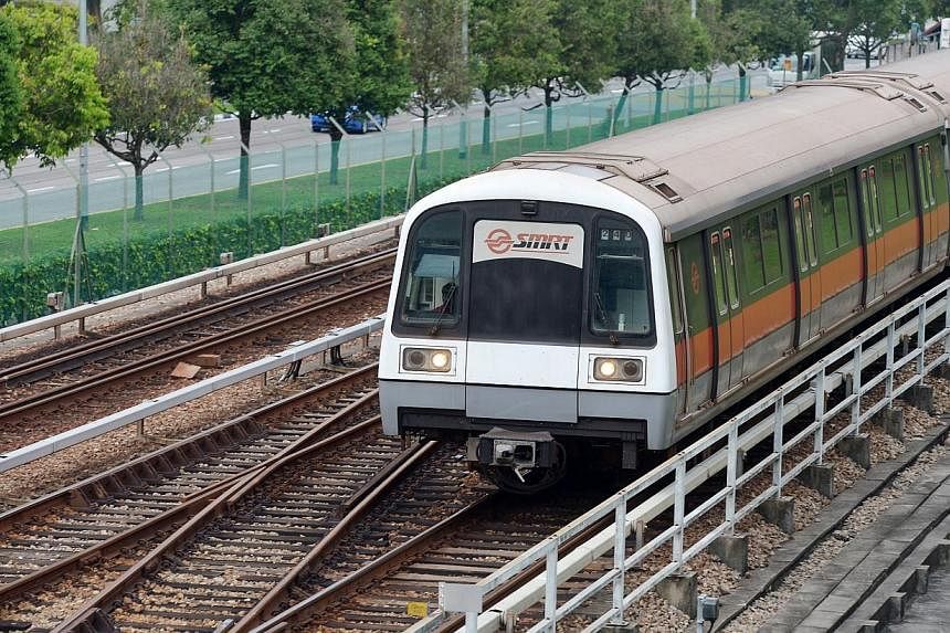 An MRT train travelling on the tracks along Ang Mo Kio Avenue 8.&nbsp;The overall waiting time on the North-South and East-West MRT lines during the peak is now 2.3 minutes, down from 2.5 in January. -- PHOTO: ST FILE
