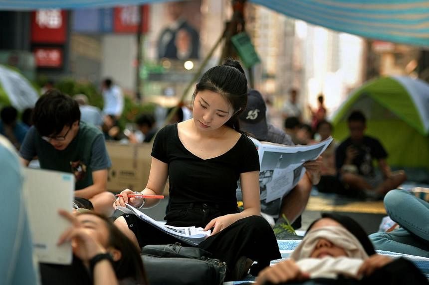 A student doing school work in the protest site in Mong Kok. Formal talks between Hong Kong student protesters and the government will take place on Friday 4pm. -- ST PHOTO:&nbsp;KUA CHEE SIONG