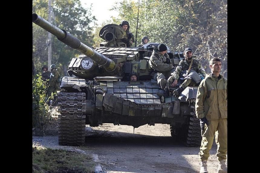 Pro-Russian rebels on a tank near the airport in Donetsk on Saturday. The best course of action for the US and Europe is to make it clear that territorial encroachment in Ukraine or elsewhere will be very costly.