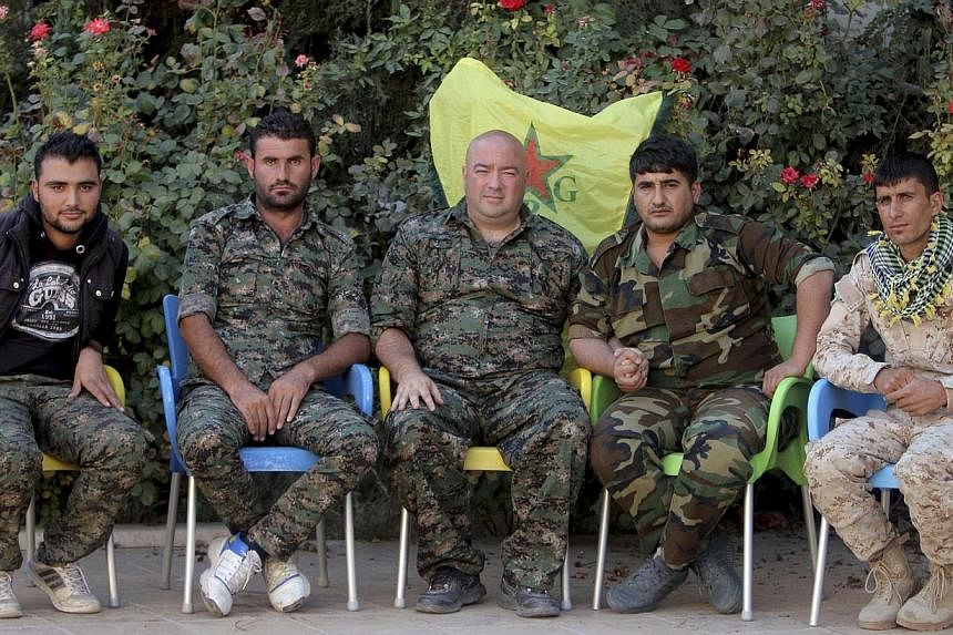 Mr Brian Wilson (middle), who said he is a US citizen and a former soldier from Ohio, and who has joined the Kurdish People's Protection Units (YPG), sits with YPG members during an interview with Reuters in the north-east Syrian Kurdish city of Qami