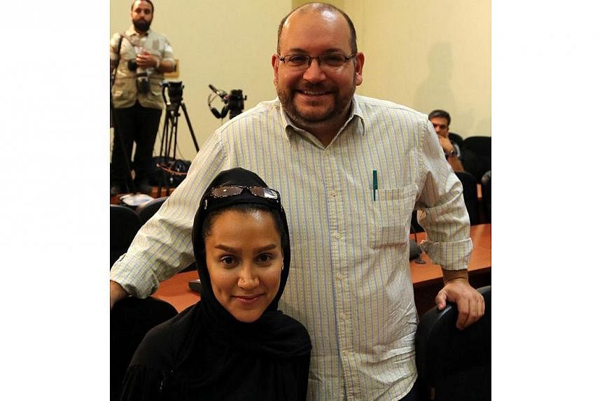 A file picture shows Iranian-American Washington Post correspondent Jason Rezaian and his Iranian wife Yeganeh Salehi posing while covering a press conference at Iran's Foreign Ministry in Tehran, on Sept 10, 2013. -- PHOTO: AFP