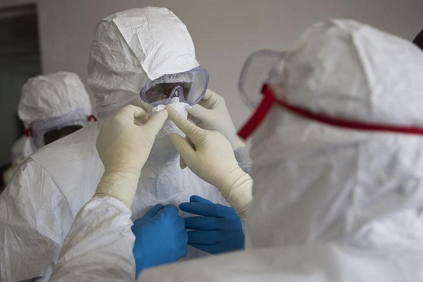 Health workers wearing protective equipment are pictured at the Island Clinic in Monrovia, on Sept 30, 2014, where patients are treated for Ebola. A Spanish assistant nurse who treated two Ebola victims at a Madrid hospital has contracted the virus h