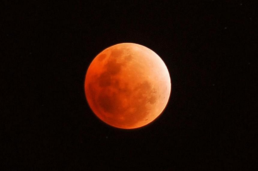 A red moon during a total lunar eclipse seen over Singapore on 10 December 2011 at 10:35pm.&nbsp;Across the world on Oct 8, sky-watchers will be casting their gaze towards the heavens for a glimpse of the rare blood moon - where the moon appears redd