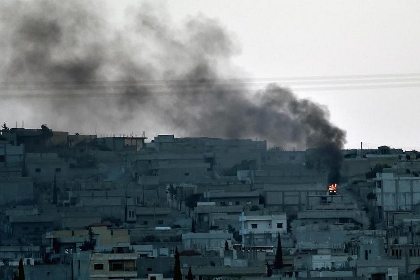 Smoke rises from the city centre of the Syrian town of Ain al-Arab, known as Kobane by the Kurds, as seen from the Turkish-Syrian border during heavy fighting, in the south-eastern town of Suruc, Sanliurfa province, on Oct 7, 2014.&nbsp;Militants fro