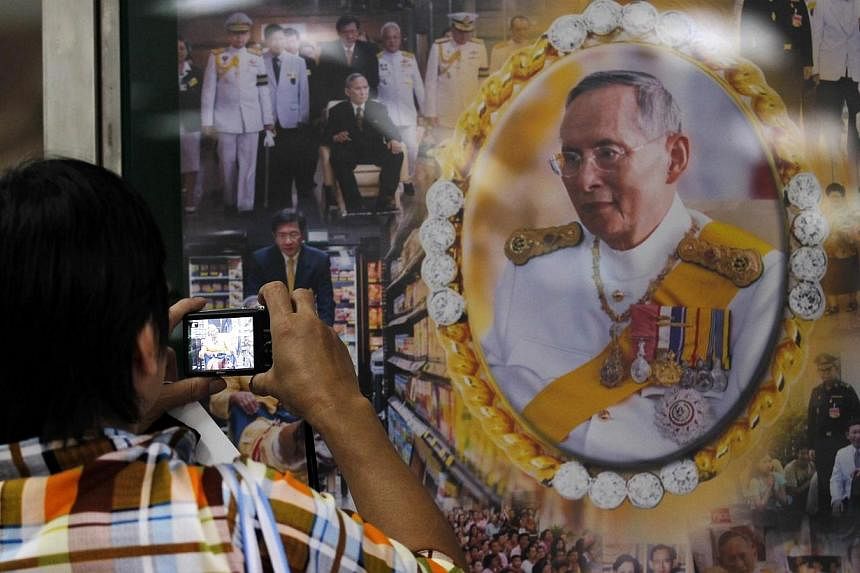 A well-wisher takes a picture of Thailand's revered King Bhumibol Adulyadej at the Siriraj hospital in Bangkok on Oct 8, 2014.&nbsp;The world's longest-serving monarch was "getting better" after a gall bladder operation following his emergency hospit