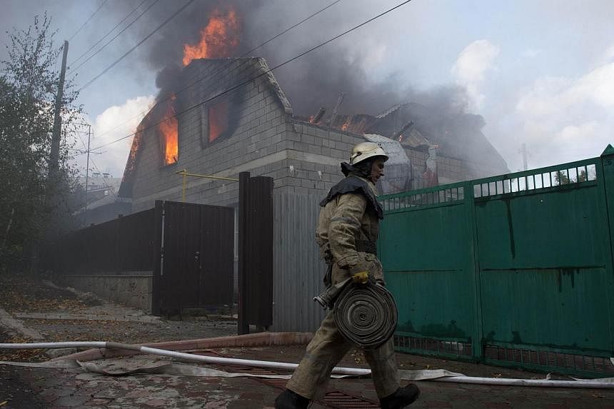 A firefighter attempts to extinguish a fire in houses hit by an Uragan missile in a north-western district in Donetsk on Oct 5, 2014.&nbsp;More than 330 people have been killed in Ukraine since a fragile truce began a month ago, with five million peo