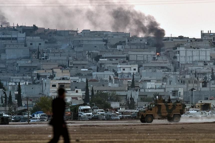 Smoke rises from the city centre of the Syrian town of Ain al-Arab, known as Kobane by the Kurds, as seen from the Turkish-Syrian border during heavy fighting, in the southeastern town of Suruc, Sanliurfa province on Oct 7, 2014.&nbsp;-- PHOTO: AFP