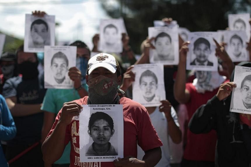 Students from Ayotzinapa Teacher Training College Raul Isidro Burgos hold pictures of missing students outside the General Attorney building in Chilpancingo, in Guerrero, on Oct 7, 2014.&nbsp;Mexico came under growing international pressure on Tuesda